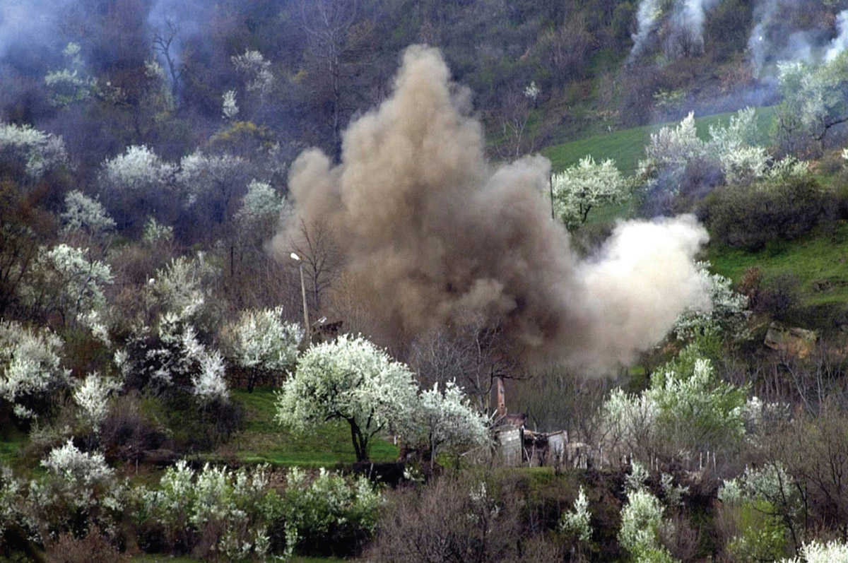 A photograph of a smoke cloud lifting above the trees.