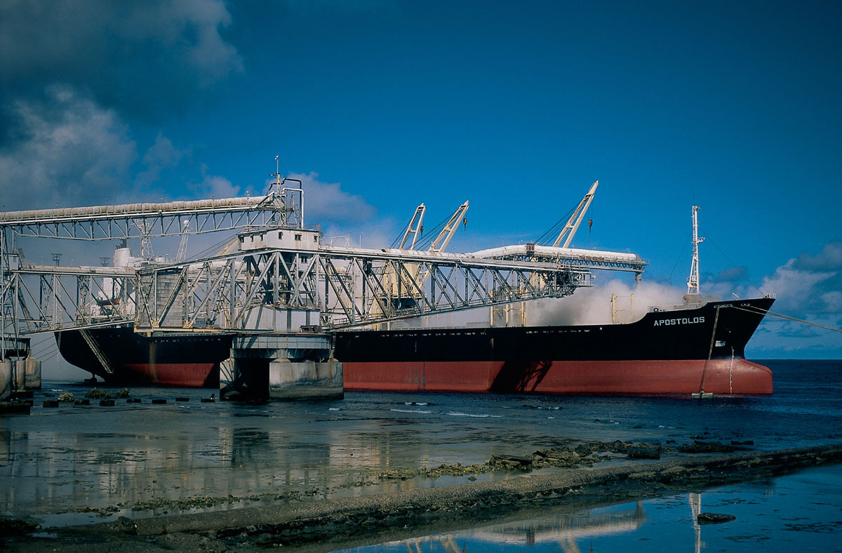 A photograph of Nauruian phosphate ore being loaded onto a ship.