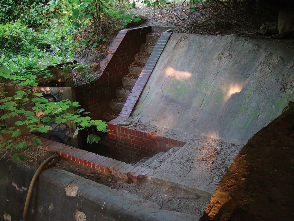 A photograph a brick staircase and concrete wall.