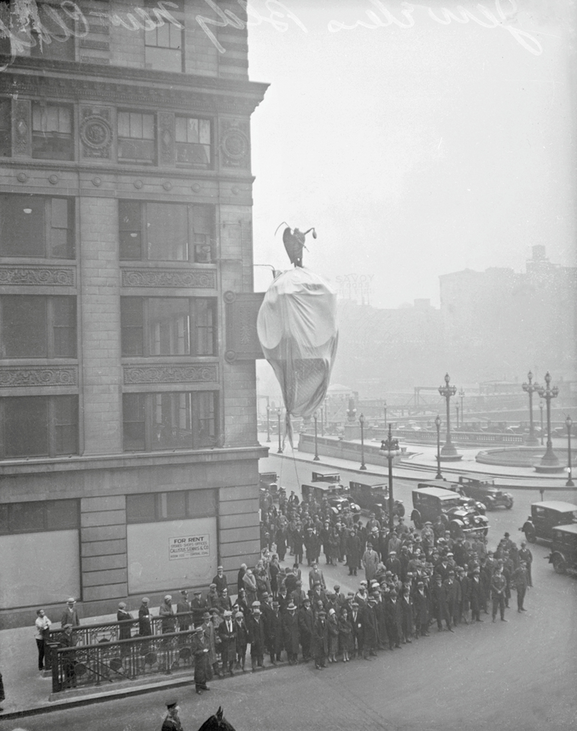 A photograph of a crowd gathered below a building in Chicago.