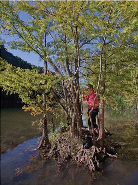 A photograph of the author standing on a small island with trees. 