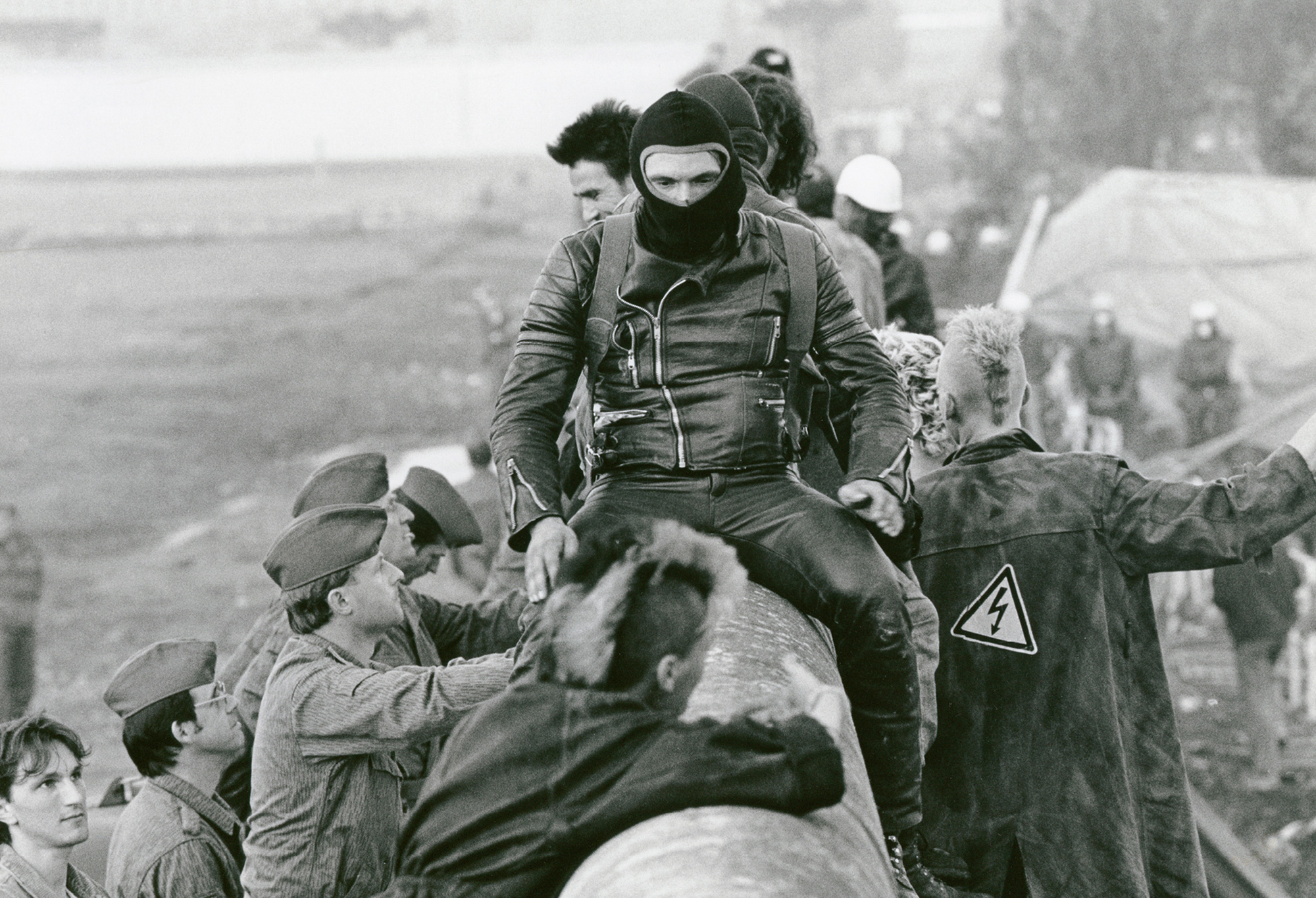 A photograph of protesters being met with police as they climbed the wall into East Berlin on the 1st of July nineteen eighty-eight.