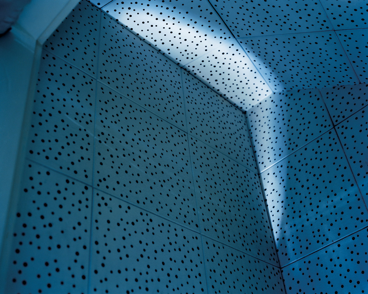 A photograph of the inside of a confessional booth, with black-dotted blue walls, which the artists associates with Saint Elizabeth.