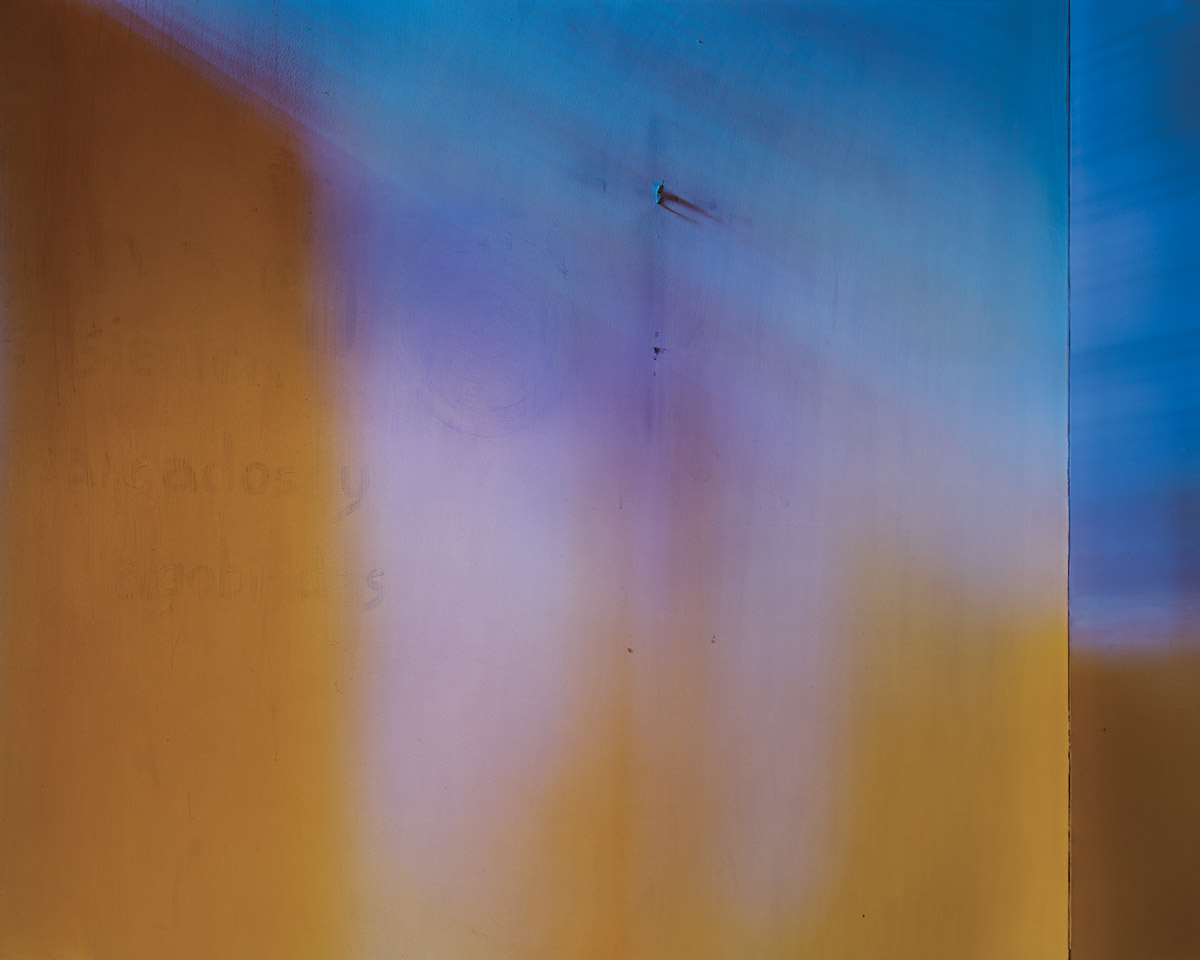 A photograph of the inside of a confessional booth, with tones of blue and purple light, which the artist associates with Saint Joseph.