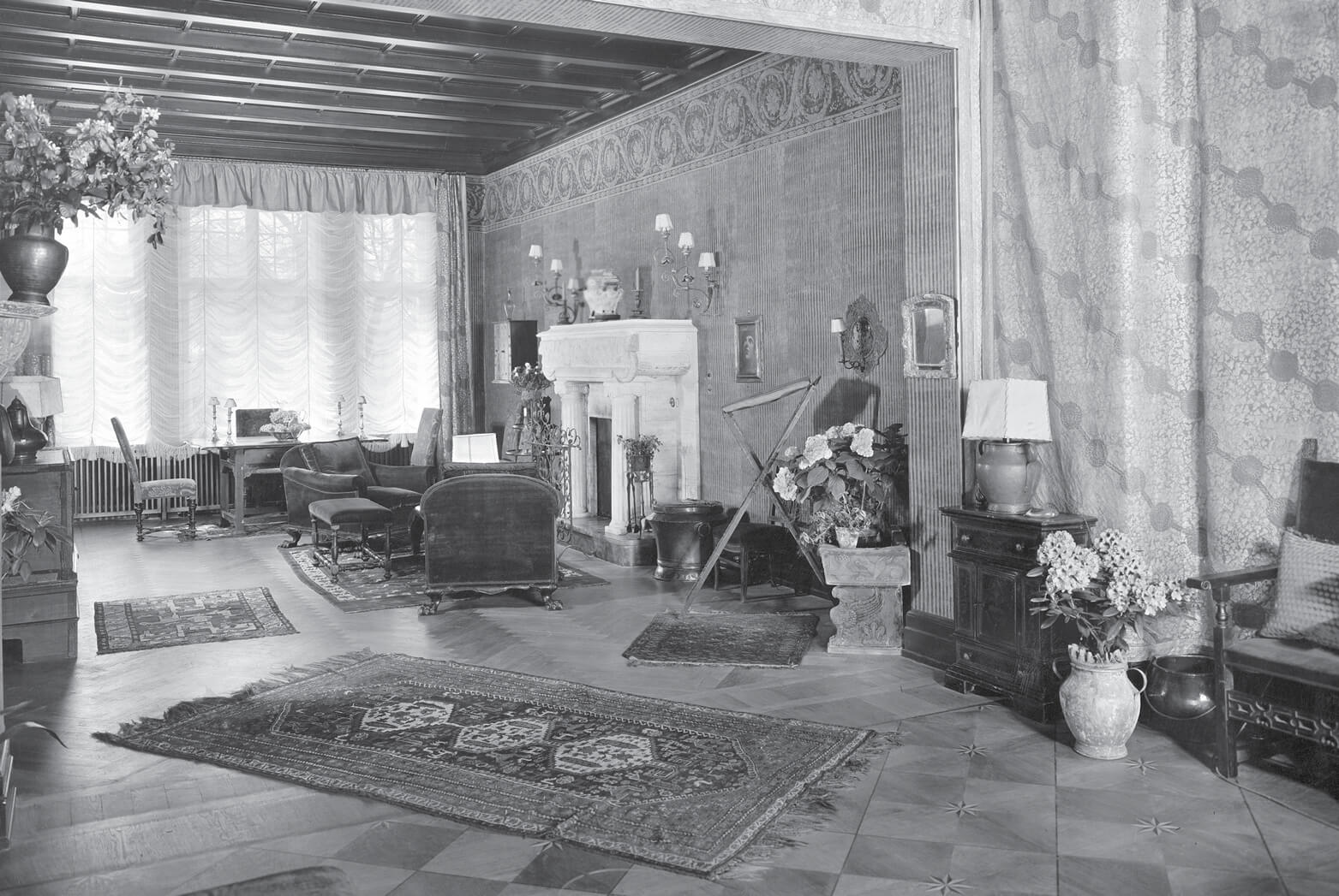 A nineteen twenty seven photograph of the interior of Murnau’s living room at Douglasstrasse twenty two. The room is influenced by baroque and antique styles, the redecoration done by Dieter Sattler and Francesco von Mendelssohn.